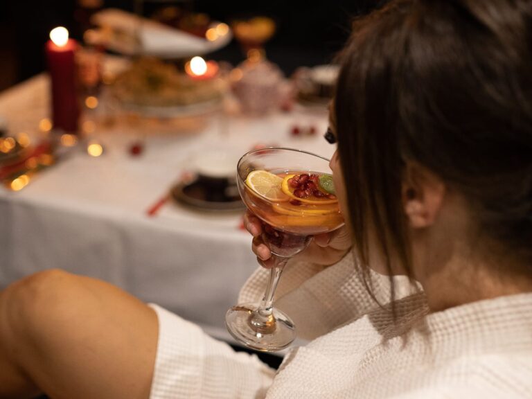 Guest in a spa robe enjoying a drink beside the afternoon tea table